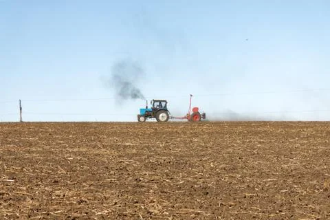 Tractor with a seeder on the field Foto stock