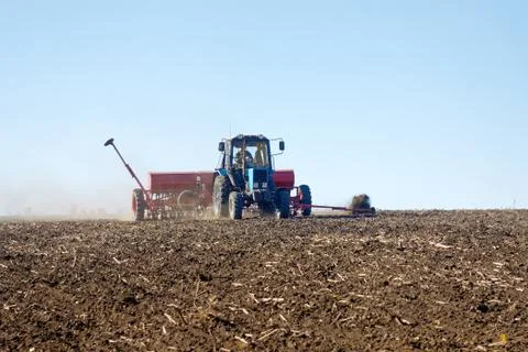 Tractor with a seeder on the field Foto stock