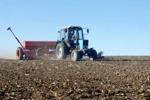 Tractor with a seeder on the field Foto stock