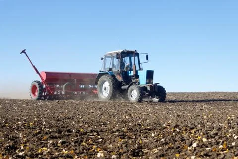Tractor with a seeder on the field Stock Photos