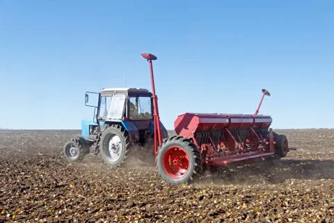 Tractor with a seeder on the field Stock Photos