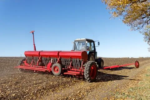 Tractor with a seeder on the field Foto stock