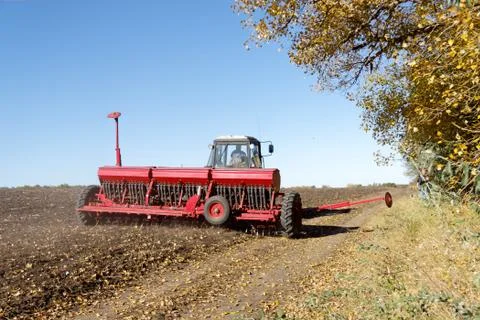 Tractor with a seeder on the field Stock Photos