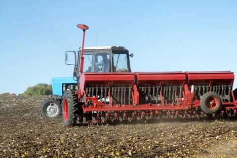 Tractor with a seeder on the field Stock Photos