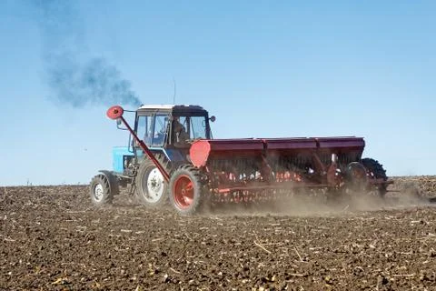 Tractor with a seeder on the field 库存照片