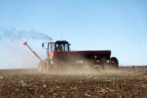 Tractor with a seeder on the field Stock Photos