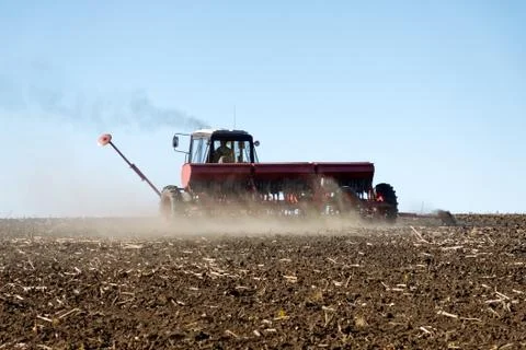 Tractor with a seeder on the field Stock Photos