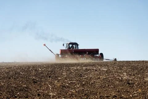 Tractor with a seeder on the field Stock Photos