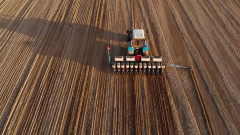 Tractor with a seeder plants row crops, fertilizes the soil, marks a landmark Stock Footage 130326329