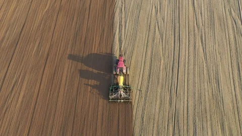 Tractor With Seeder Sows Corn Grains In Fertilized Land Of Rural Field Aerial Stock Footage 122735280