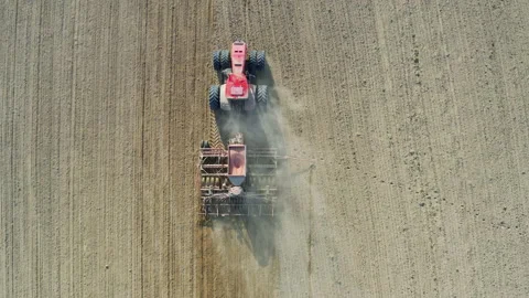Tractor with seeder sows seeds or grain of wheat or corn, rides on field Stock-Footage 144002489