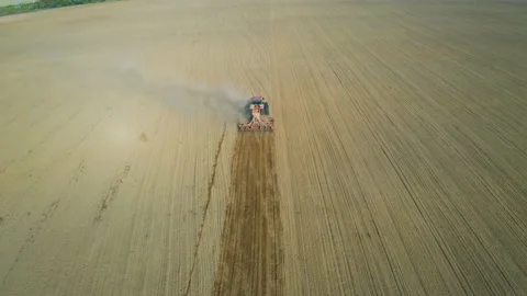 Tractor with a seeder sows seeds or grain of wheat or corn, works on field Видео 144069280