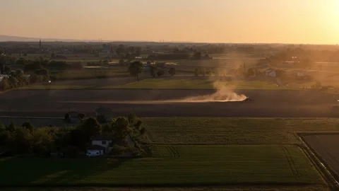 Tractor seeding field at sunset with dust cloud in Po Valley Italy slow motion Stock Footage 335965404