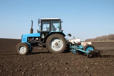 Tractor with sower on the field Stock Photos