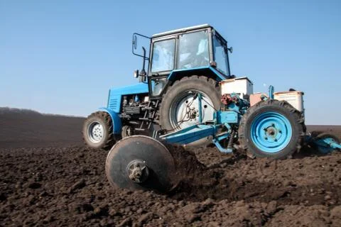 Tractor with sower on the field Stock Photos