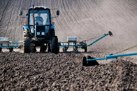 Tractor with sower on the field Stock Photos