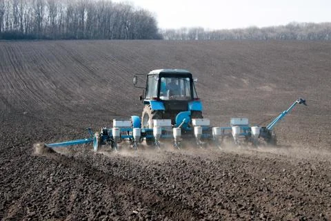 Tractor with sower on the field Stock Photos