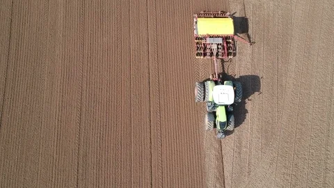 Tractor sowing crop on spring field, aerial view Stock Footage 90088405