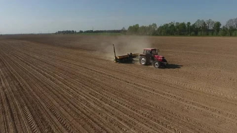 Tractor with a sowing machine is sowing wheat and corn. Farm and sowing equipmen Stock Footage 223531222