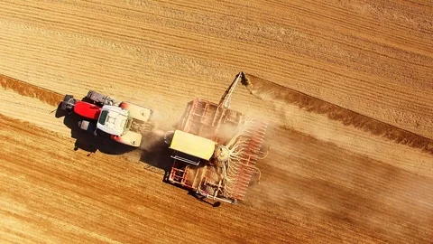 Tractor with sowing machine working on a  field. Stock-Footage 105871506