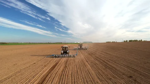 Tractor sowing seed on plowed field. Sowing seeds of corn and sunflower. Vídeo Stock 193720281