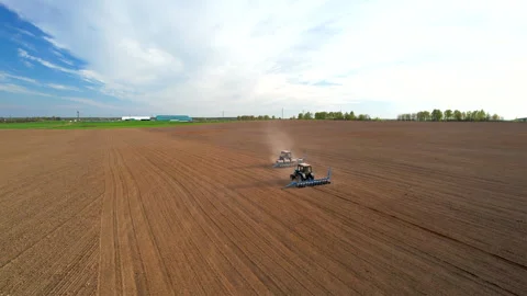 Tractor sowing seed on plowed field. Sowing seeds of corn and sunflower. 스톡 동영상 193721192