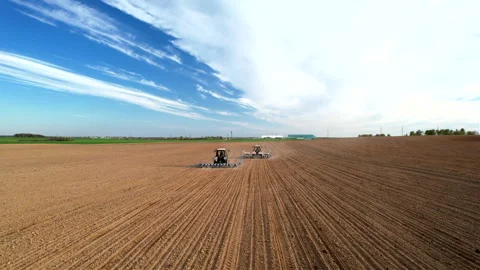 Tractor sowing seed on plowed field. Sowing seeds of corn and sunflower. Stock Footage 193721261