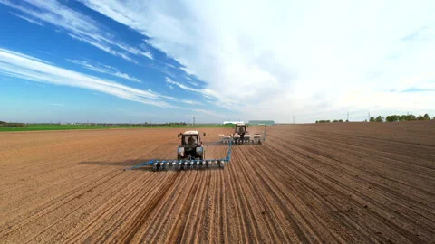 Tractor sowing seed on plowed field. Sowing seeds of corn and sunflower. Video stock 193723305