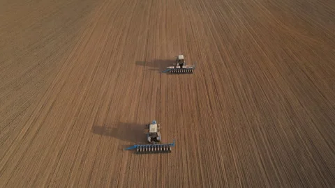 Tractor sowing seed on plowed field. Sowing seeds of corn and sunflower. Vídeos de archivo 193723358