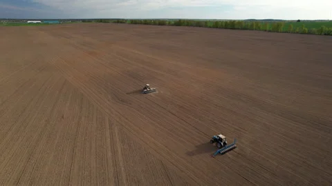 Tractor sowing seed on plowed field. Sowing seeds of corn and sunflower. 스톡 동영상 193723462