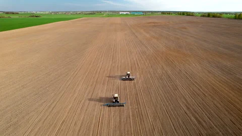 Tractor sowing seed on plowed field. Sowing seeds of corn and sunflower. Видео 193723531
