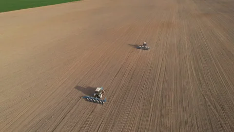 Tractor sowing seed on plowed field. Sowing seeds of corn and sunflower. Stock Footage 193731082