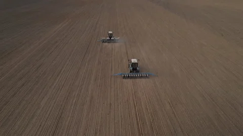 Tractor sowing seed on plowed field. Sowing seeds of corn and sunflower. Stockbeeldmateriaal 193733176