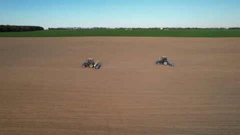 Tractor sowing seed on plowed field. Sowing seeds of corn and sunflower. Stock Footage 193748613