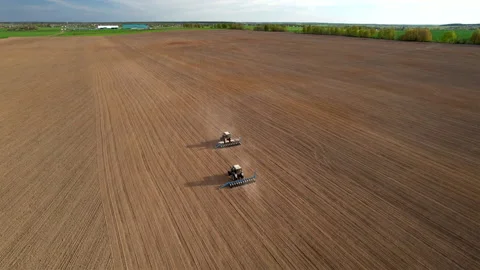 Tractor sowing seed on plowed field. Sowing seeds of corn and sunflower. Видео 193946638