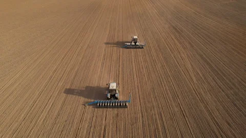 Tractor sowing seed on plowed field. Sowing seeds of corn and sunflower. 스톡 동영상 193947559