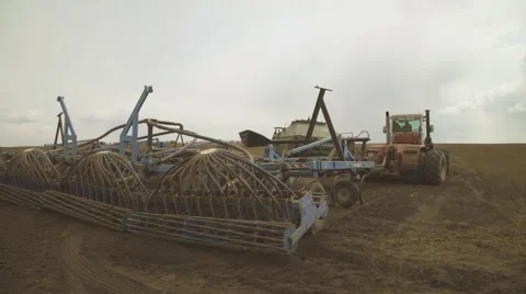A tractor with a sowing unit starts to sow plowed field Stock Footage 64591014