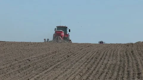 A tractor sows a field with grain. Close-up of a seeder. Video stock 282197661