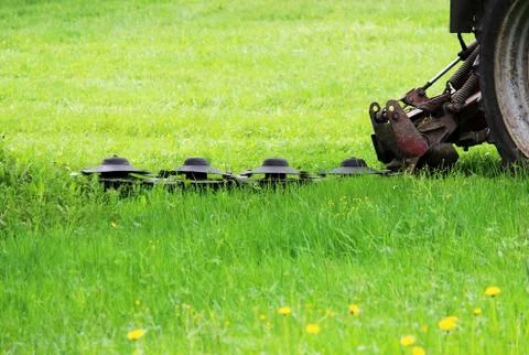 The tractor with a special nozzle automatically mows the grass Stock Photos