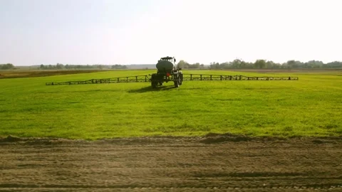 Tractor sprayer irrigates the field. Application of fertilizers and pesticides Stock Footage 234421694
