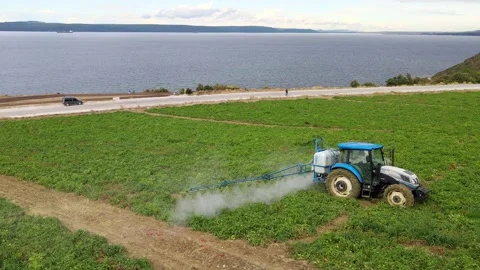 A tractor with a sprayer makes fertilizer in the field. Video stock 225514444