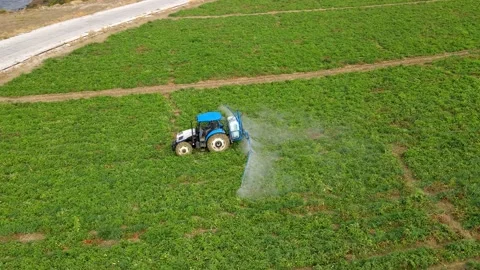 A tractor with a sprayer makes fertilizer in the field. Stock Footage 225517417
