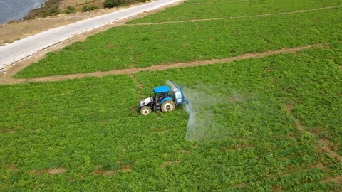 A tractor with a sprayer makes fertilizer in the field. Video stock 225544319