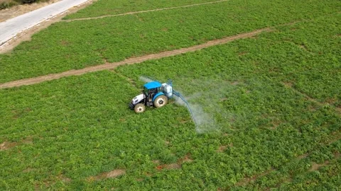 A tractor with a sprayer makes fertilizer in the field. Video stock 225548268