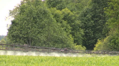 Tractor sprayer sitting stream with fertilizer on crop field Stock Footage 48989049