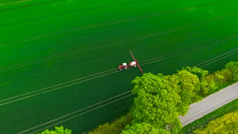 Tractor with sprayer in wheat field spraying for farming care. Agricultural Stock Footage 311932468