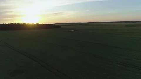 Tractor spraying big endless green field on the sunset. Aerial drone shot Stock Footage 133998841