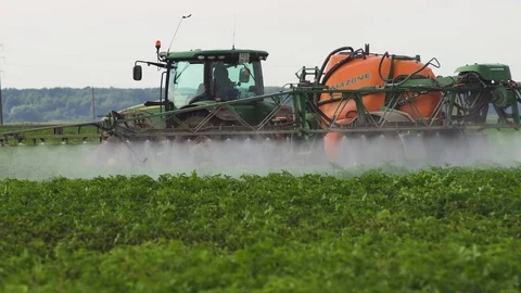Tractor is spraying fertilizers field. Stock Footage