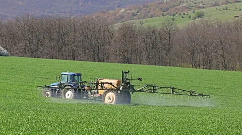 Tractor spraying field, rural landscape in countryside Stock Footage 63237019
