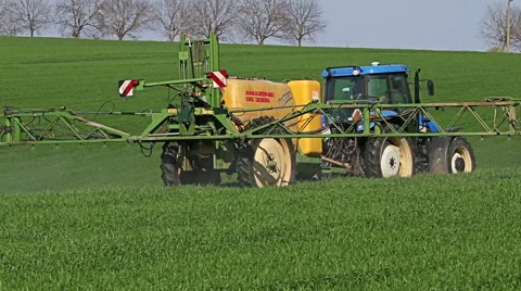 Tractor spraying field, rural landscape in countryside 스톡 동영상 63237676